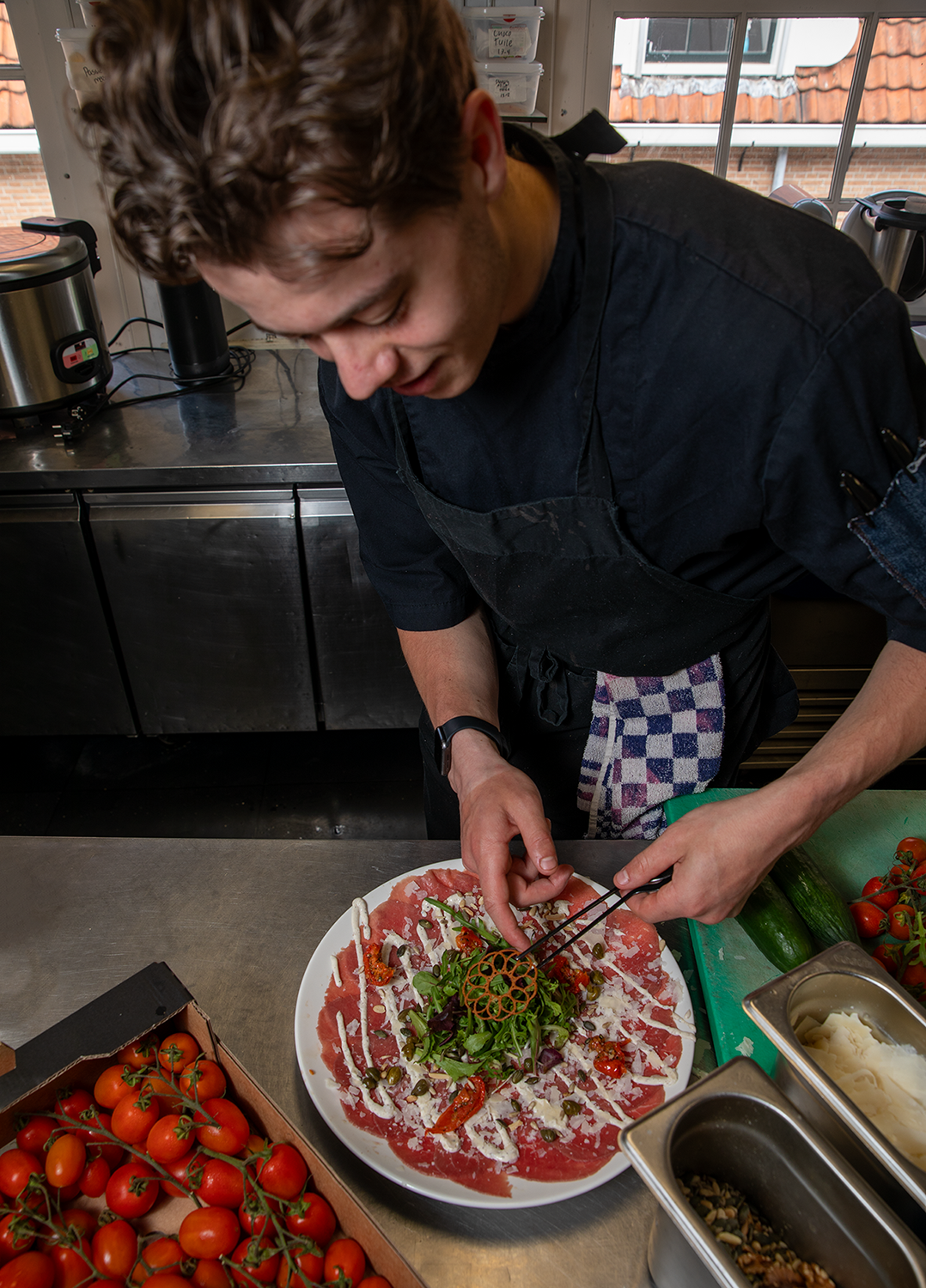 Kok maakt een carpaccio af in de keuken