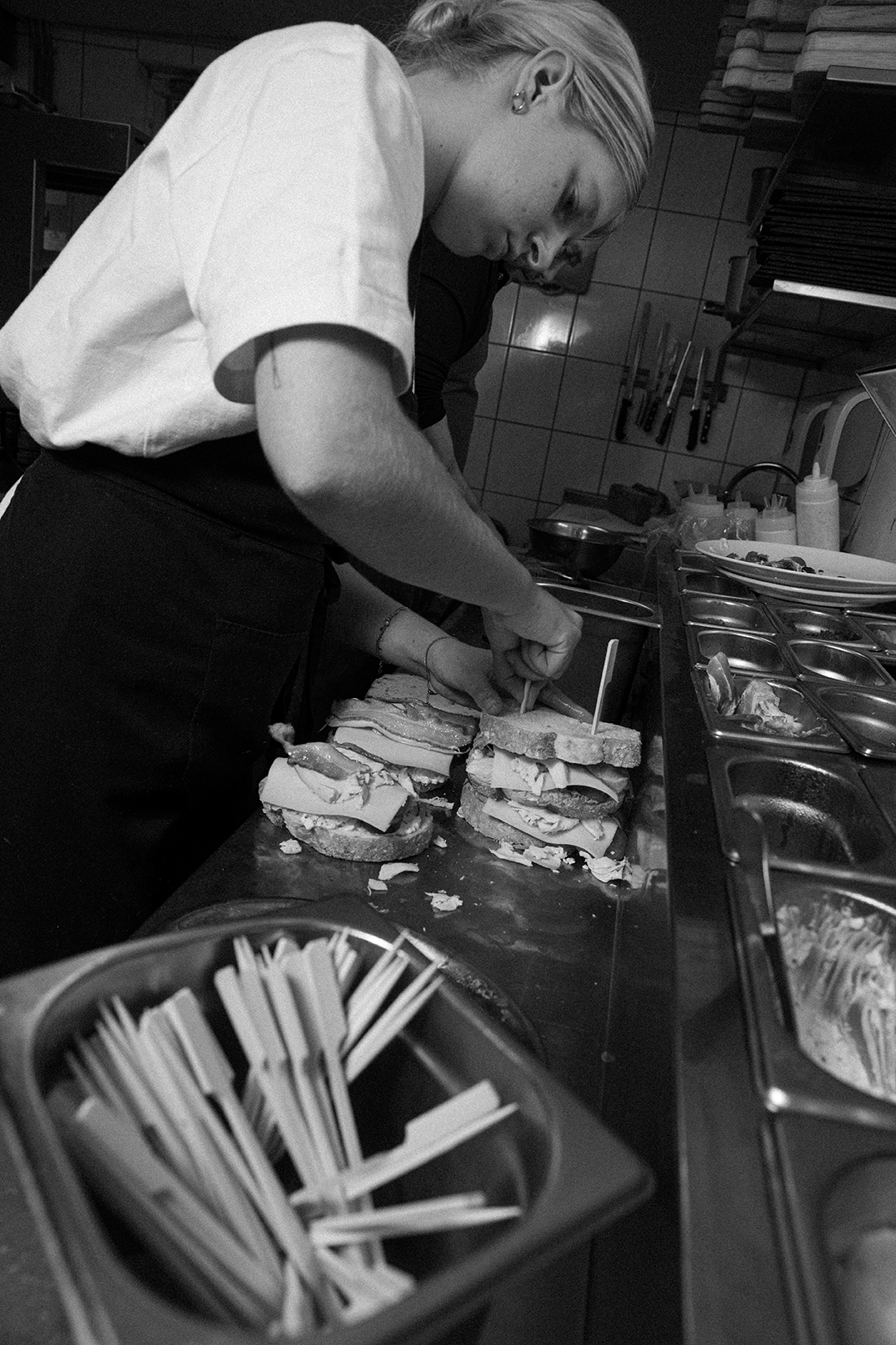 Medewerker maakt broodjes af in de keuken